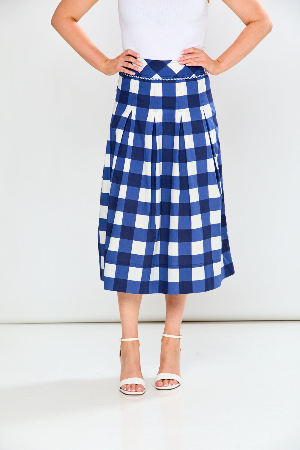 Person wearing a blue and white checkered skirt on a white background