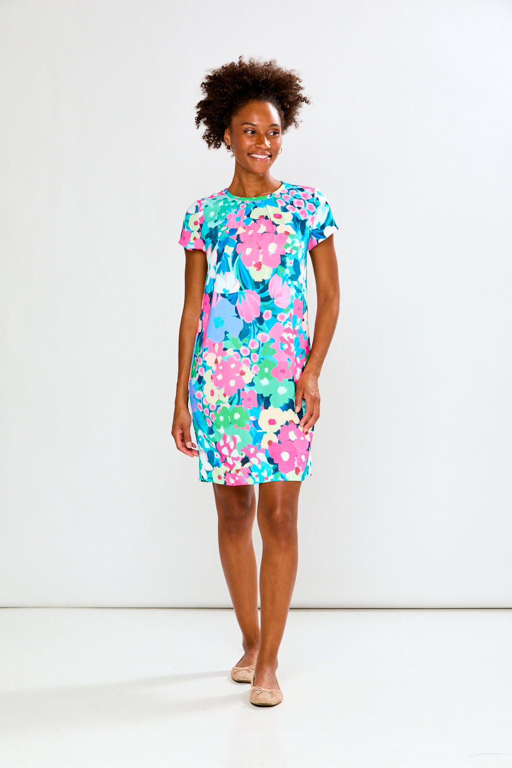 Woman wearing a colorful floral dress on a white background