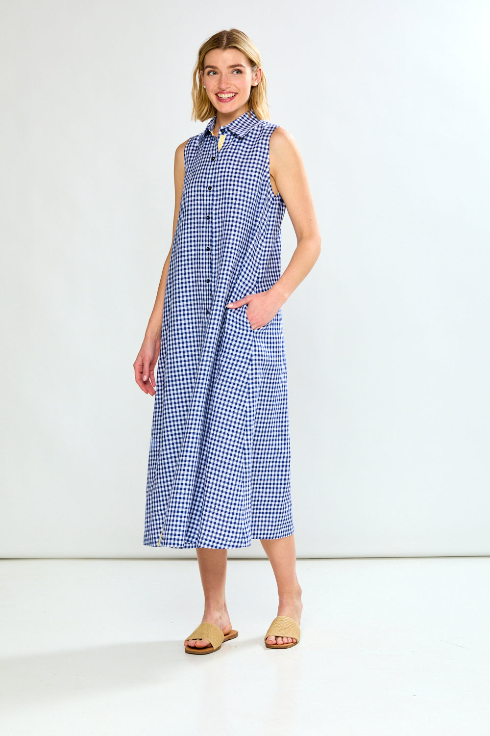 Woman wearing a blue checkered dress against a white background