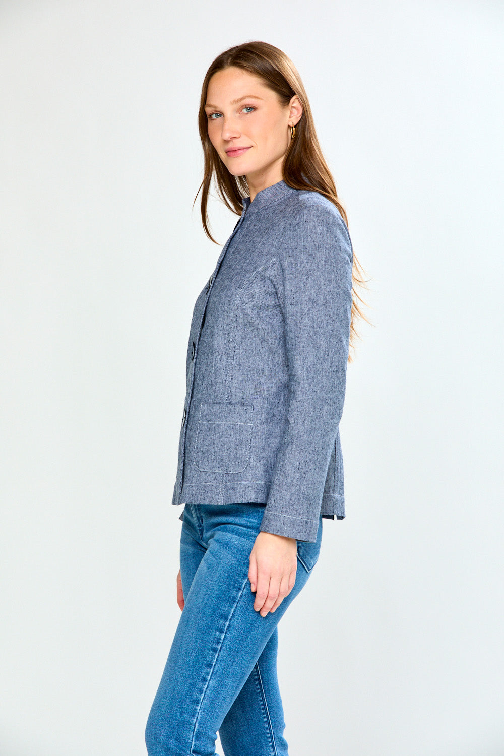 Woman wearing a blue blazer and jeans on a white background