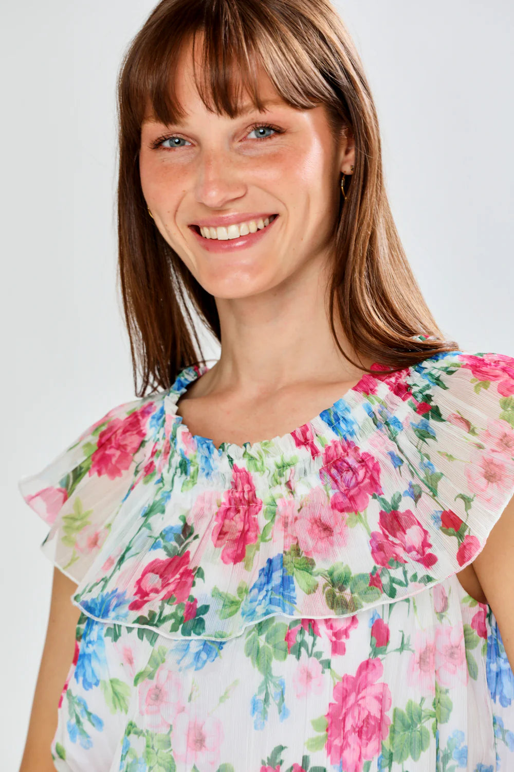 Woman wearing a floral dress against a plain background