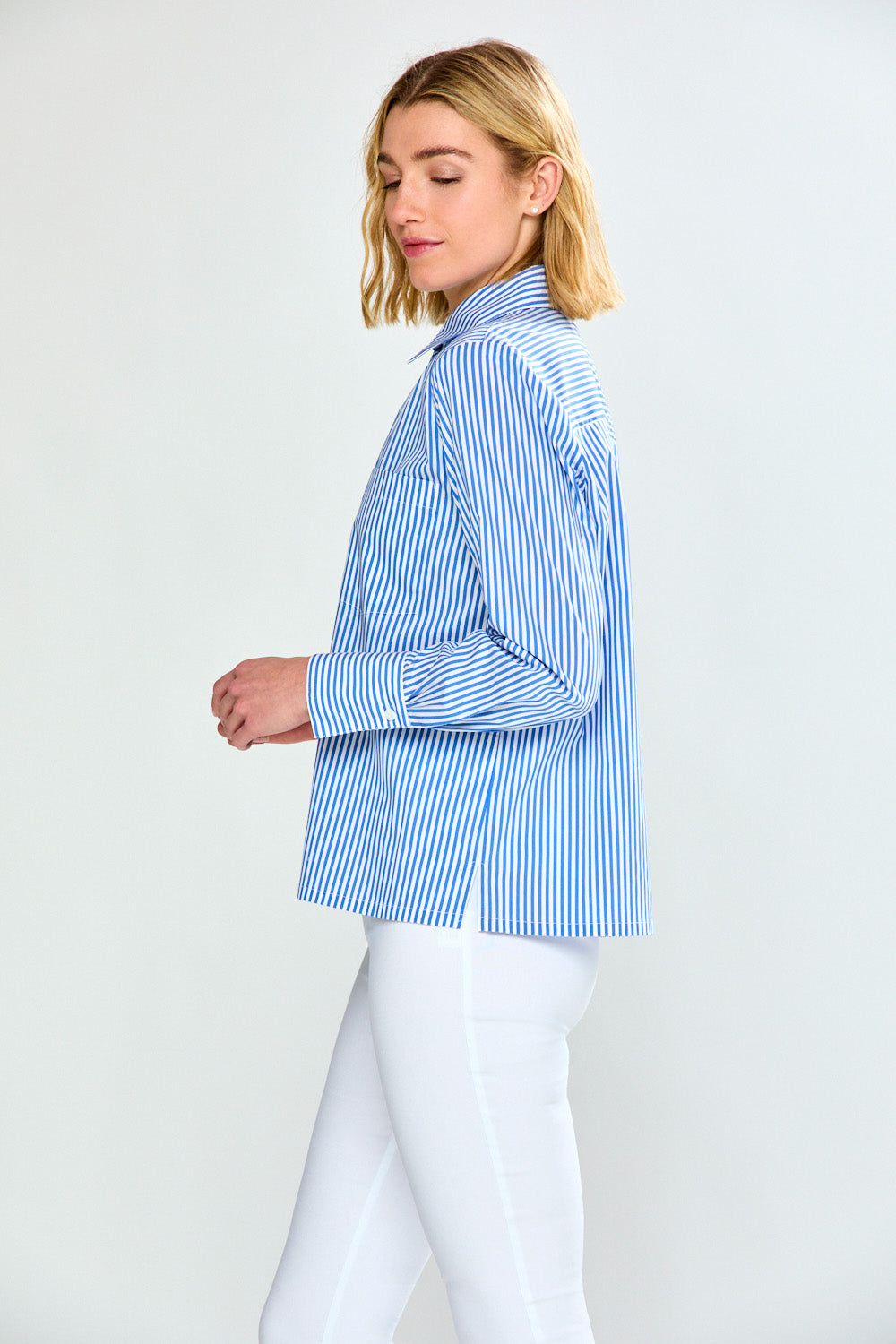 Woman wearing a blue and white striped shirt on a plain background