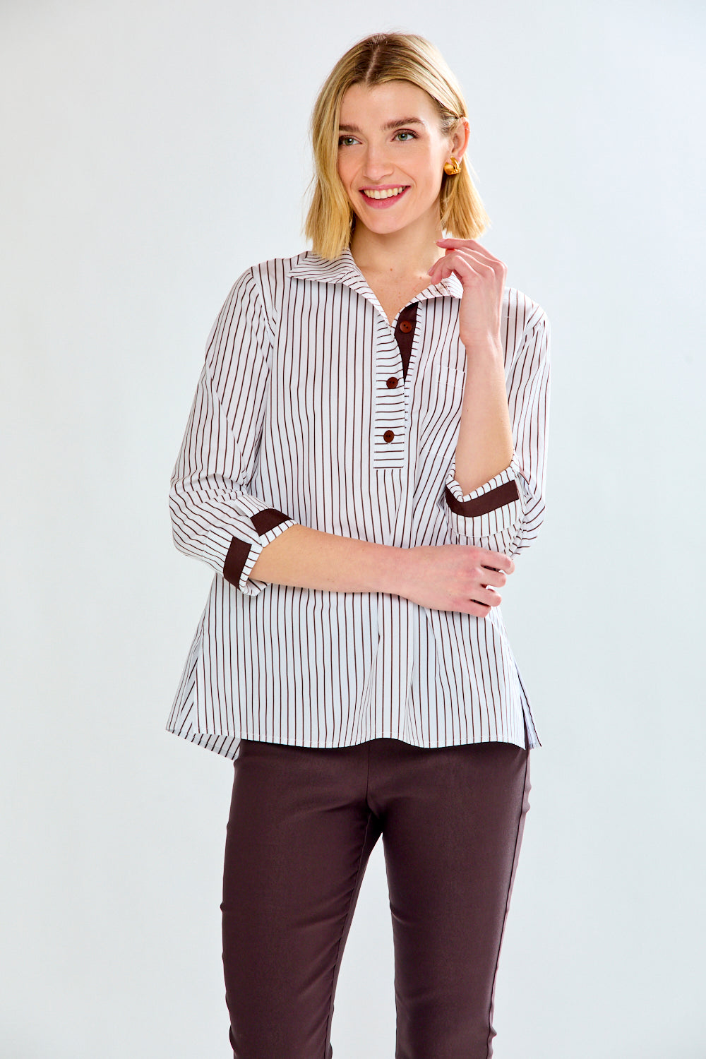 Woman wearing a striped shirt with brown accents on a white background