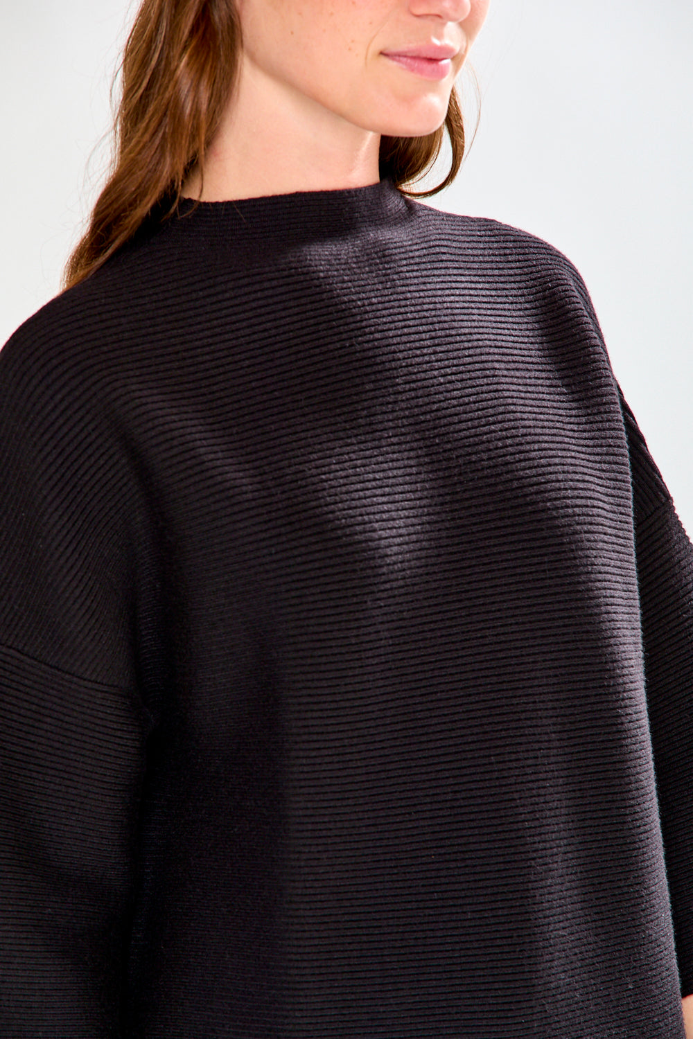 Woman in black ribbed sweater