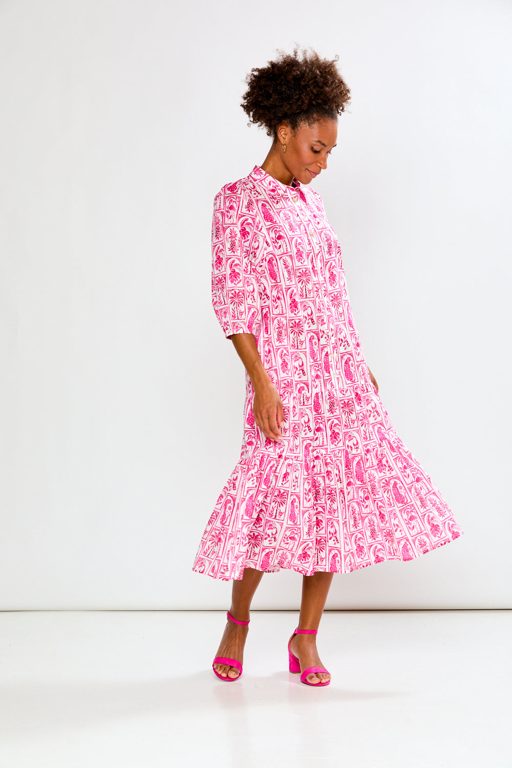 Woman wearing a pink and white patterned dress on a white background