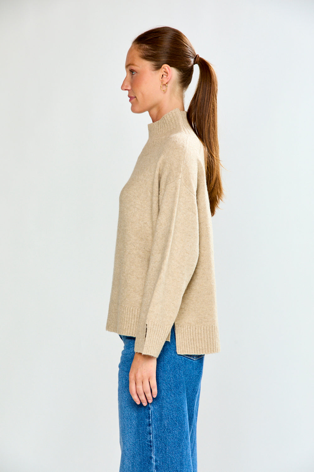 Woman in oat sweater with jeans
