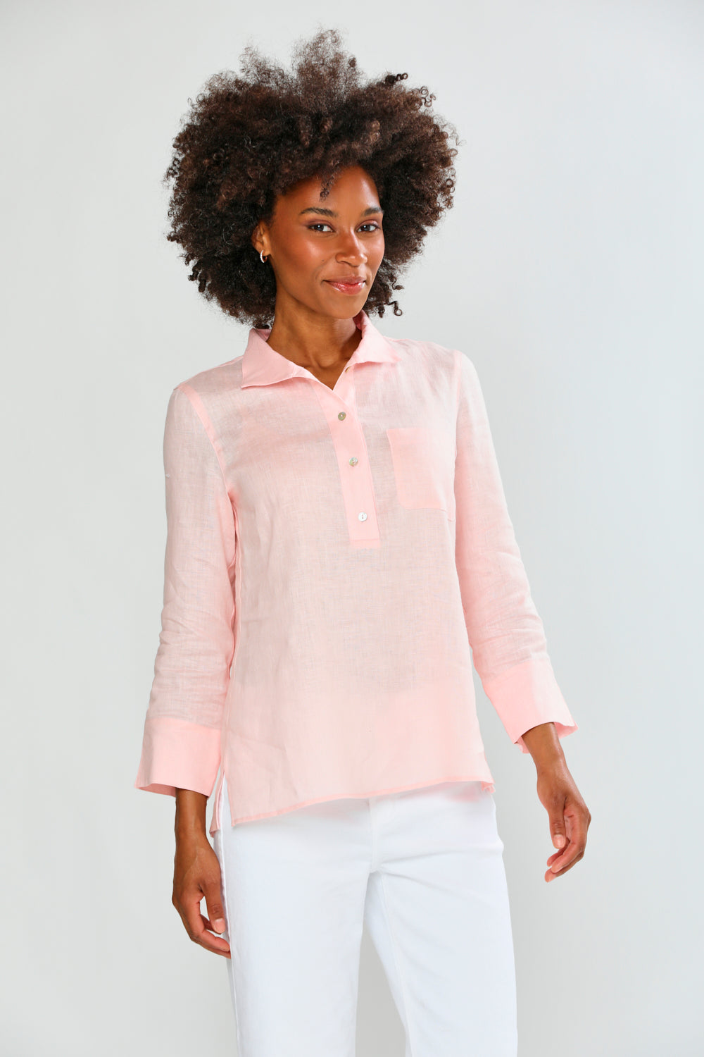 Woman wearing a light pink blouse against a plain background
