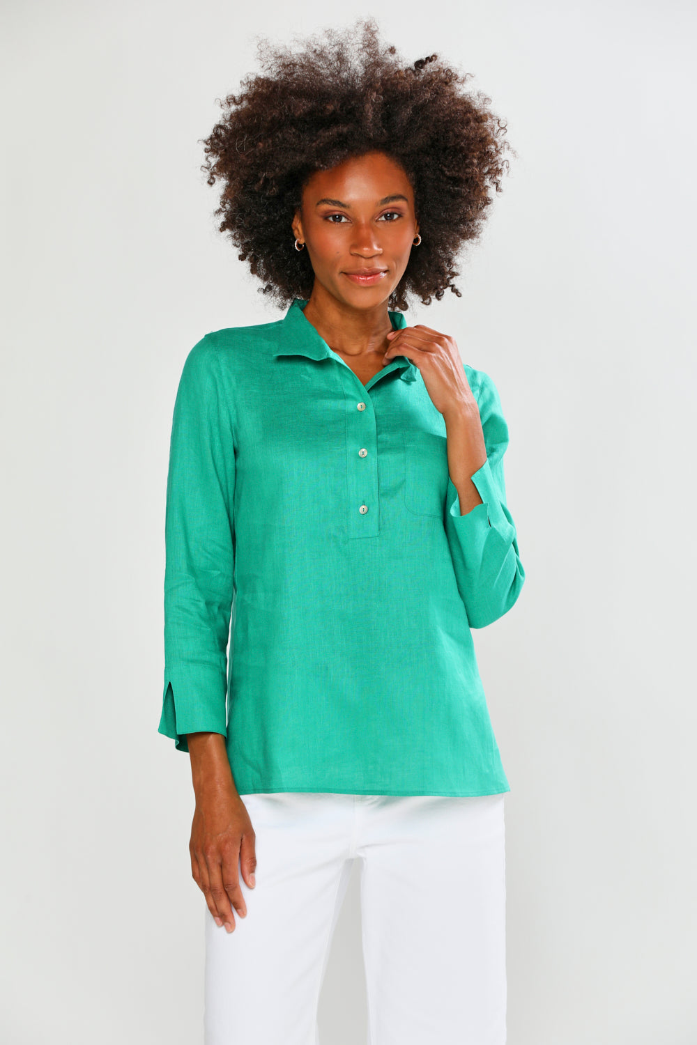 Woman wearing a green long-sleeve shirt against a white background