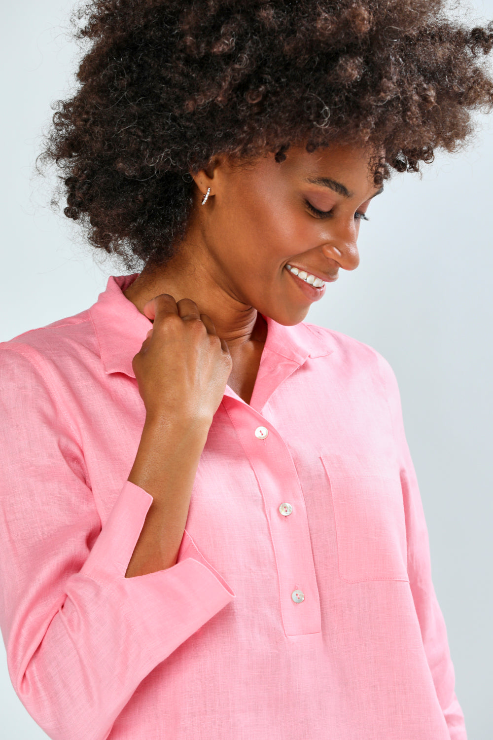 Woman wearing a pink shirt against a light gray background
