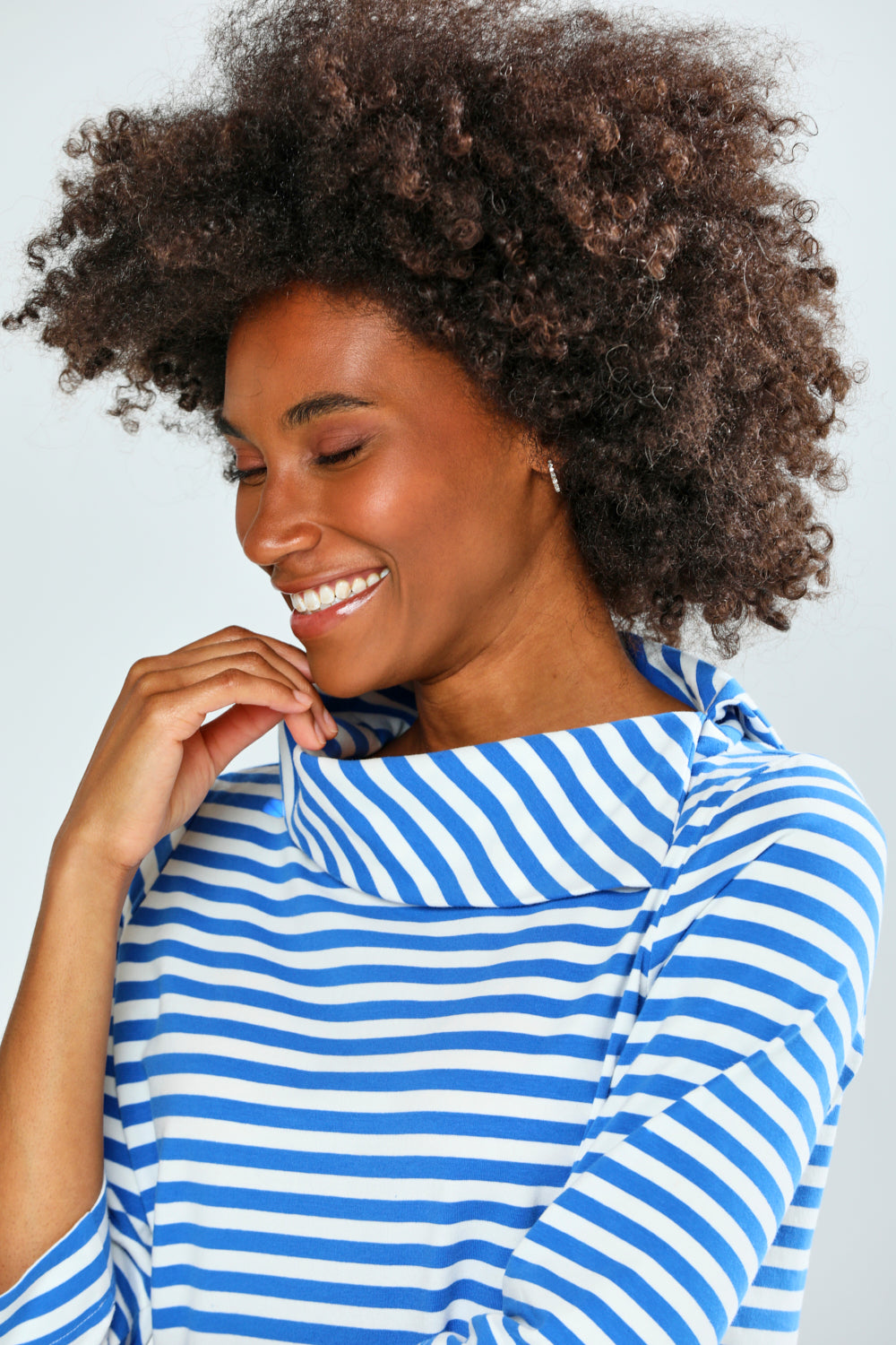 Woman wearing a blue and white striped shirt against a plain background