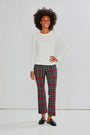 Woman wearing a white sweater and plaid pants on a white background