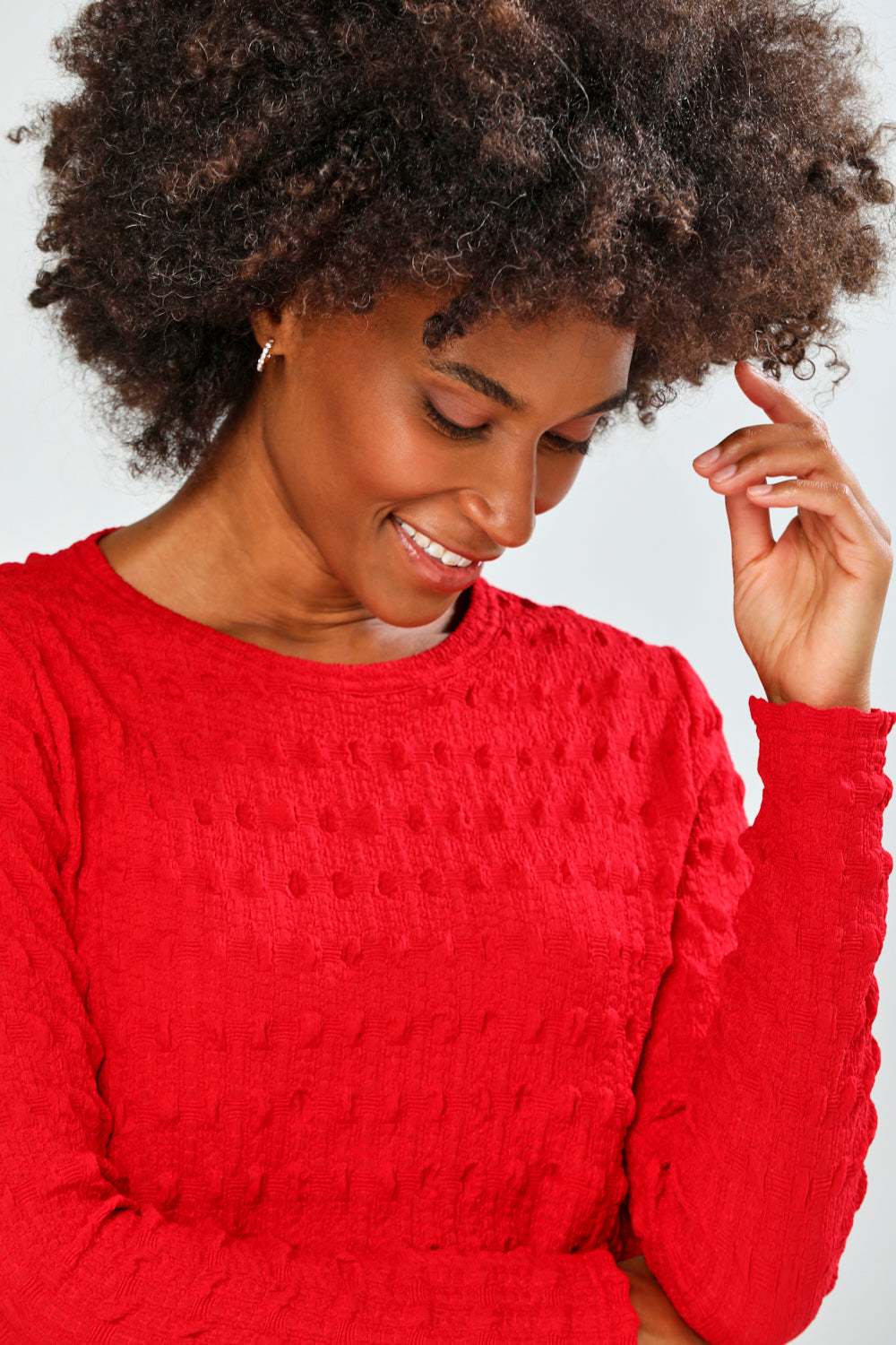 Woman wearing a red top and plaid pants on a white background