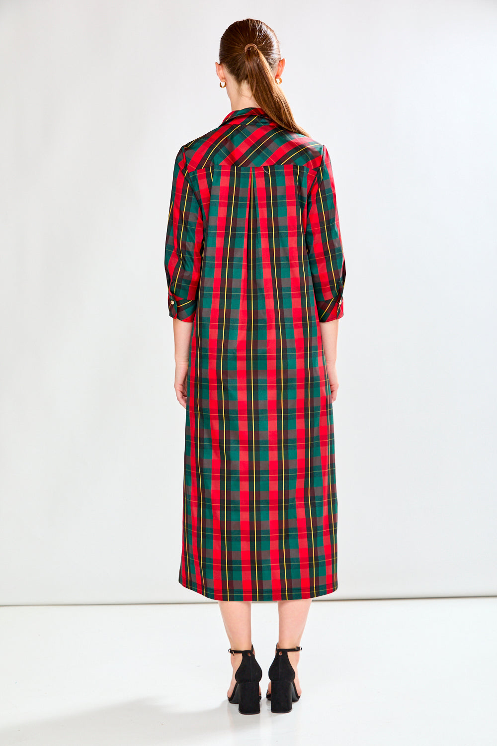 Woman wearing a red and green plaid dress on a white background