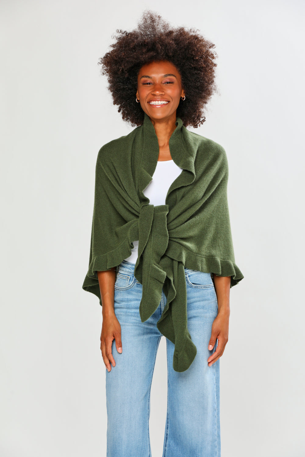 Woman wearing a green scarf and light blue jeans on a white background