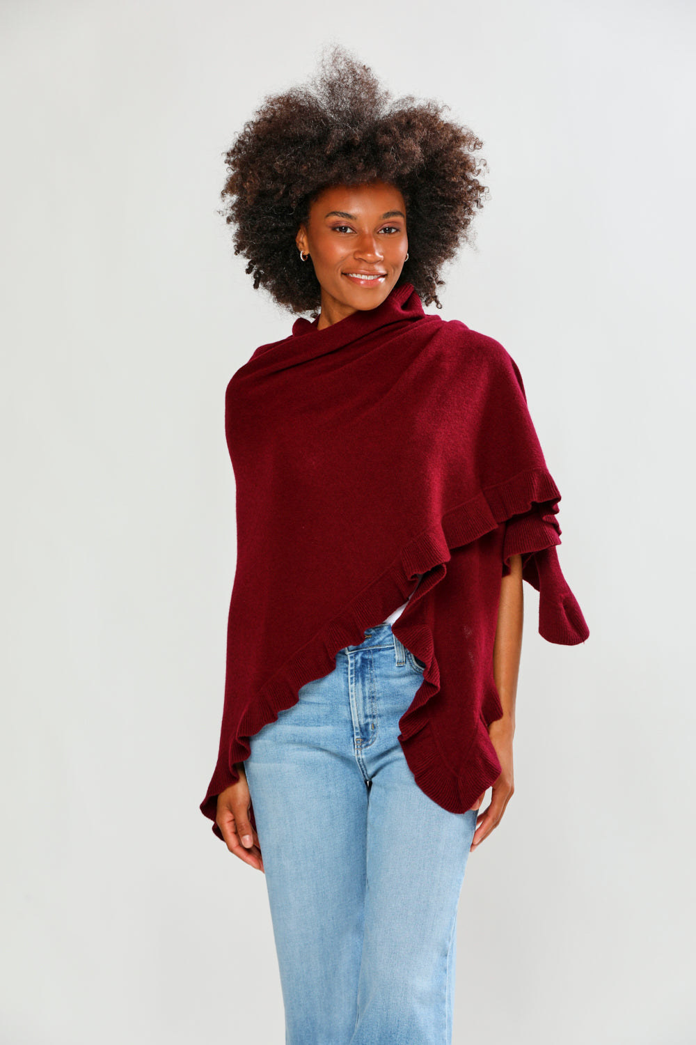Woman wearing a burgundy poncho over a white background