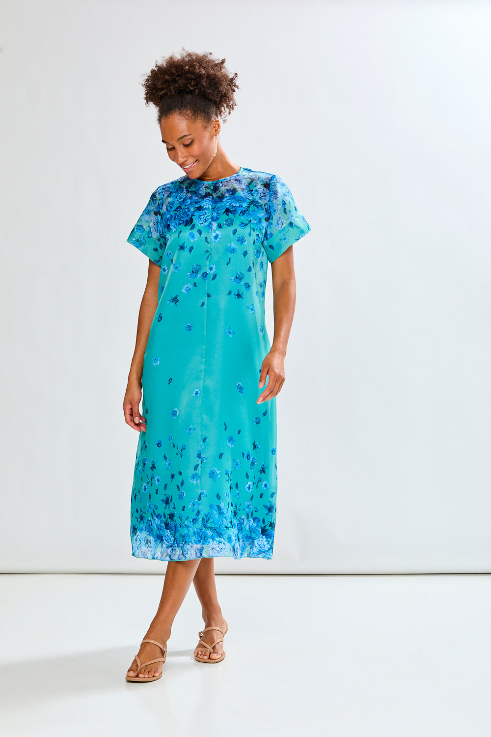 Woman wearing a blue floral dress against a white background
