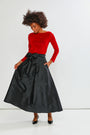 Woman wearing a red top and black skirt on a white background