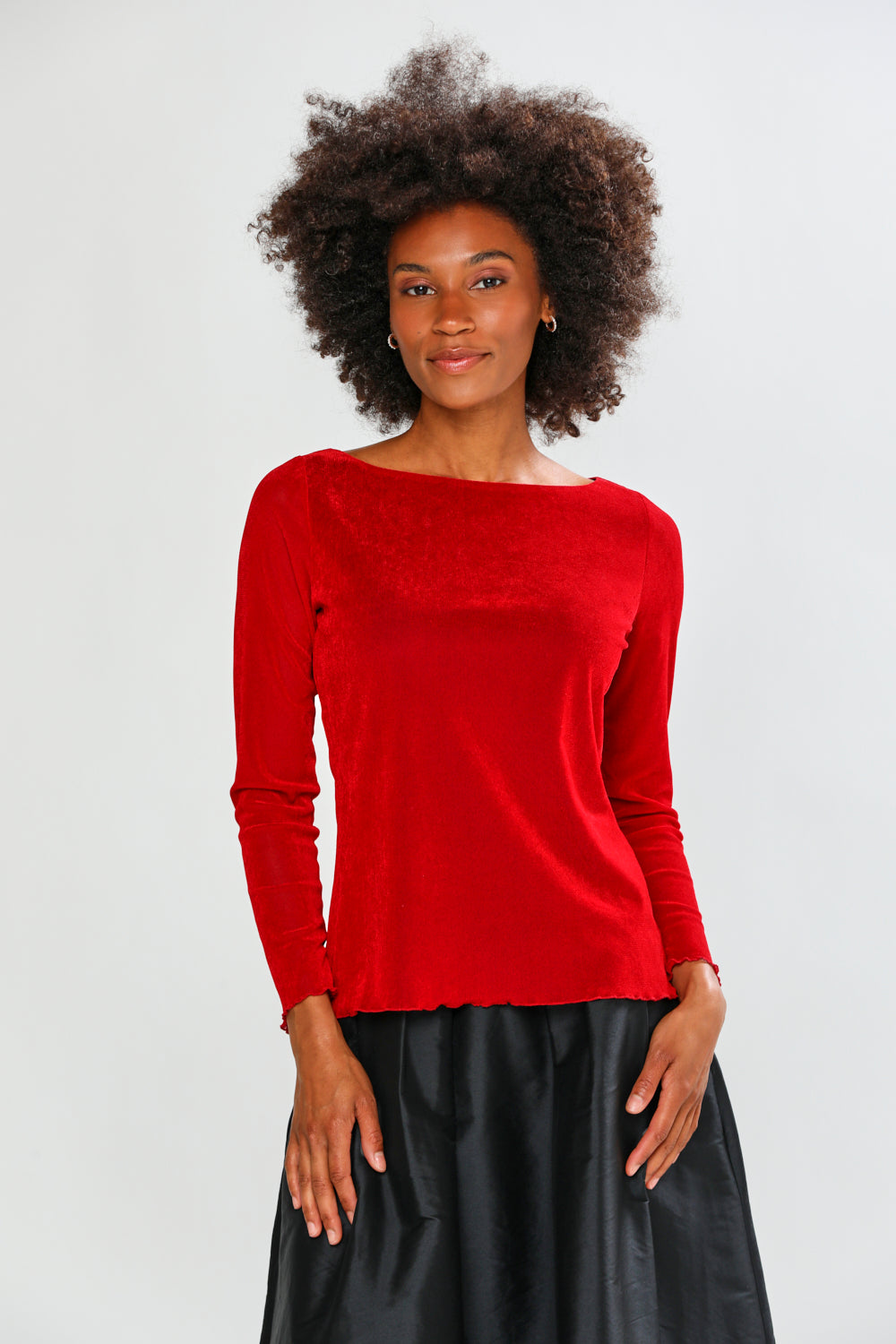 Woman wearing a red blouse and black skirt on a white background