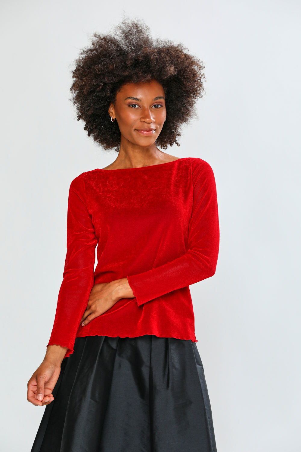 Woman wearing a red blouse and black skirt on a white background