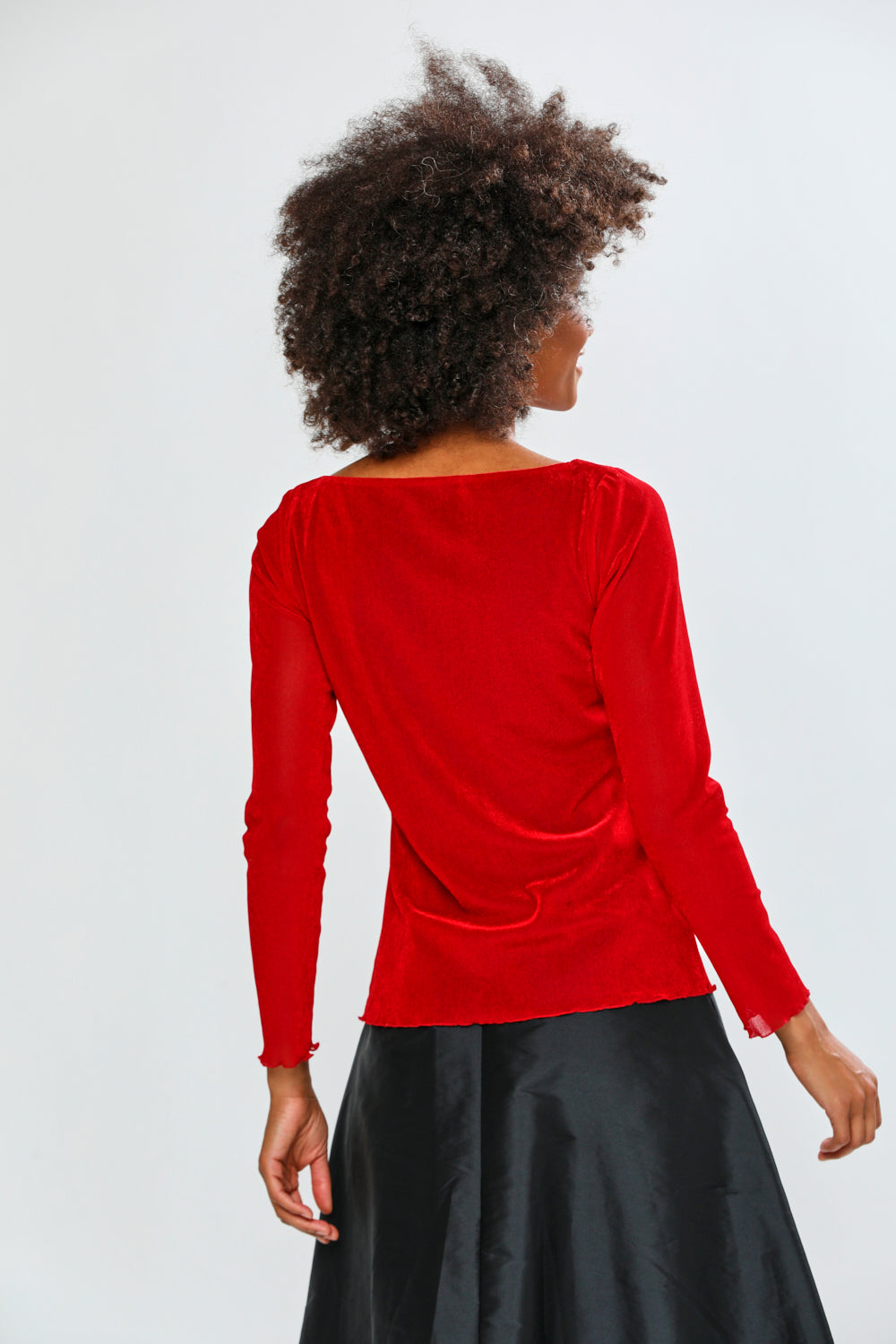 Person wearing a red blouse with a plain background