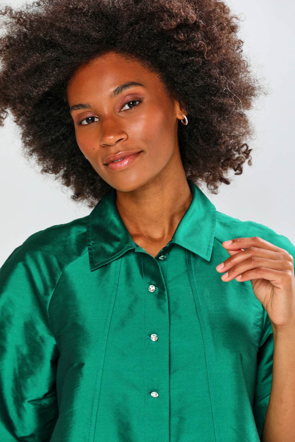 Woman wearing a green blouse against a plain background