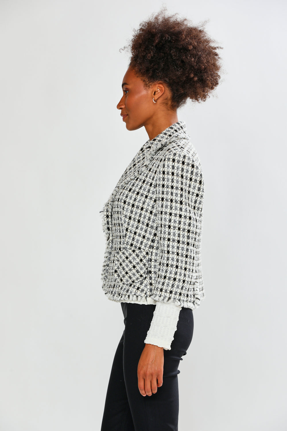 Woman wearing a black and white checkered jacket on a white background