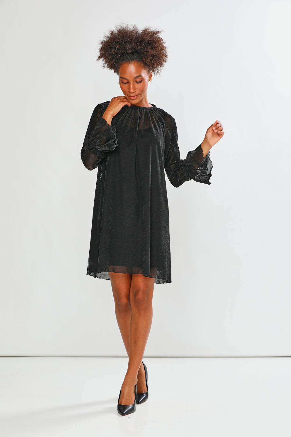 Woman wearing a black dress against a white background