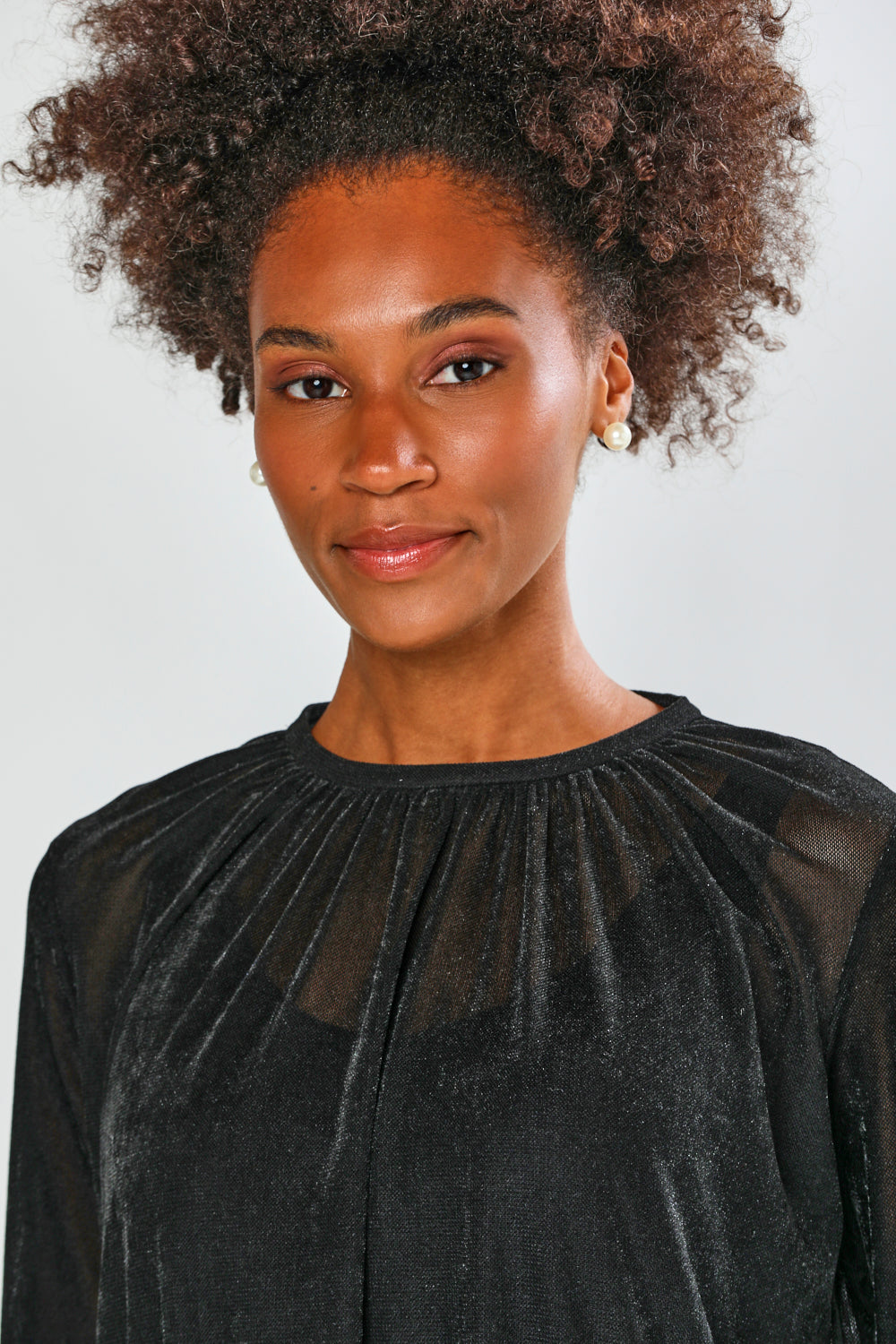 Woman wearing a black top against a plain background