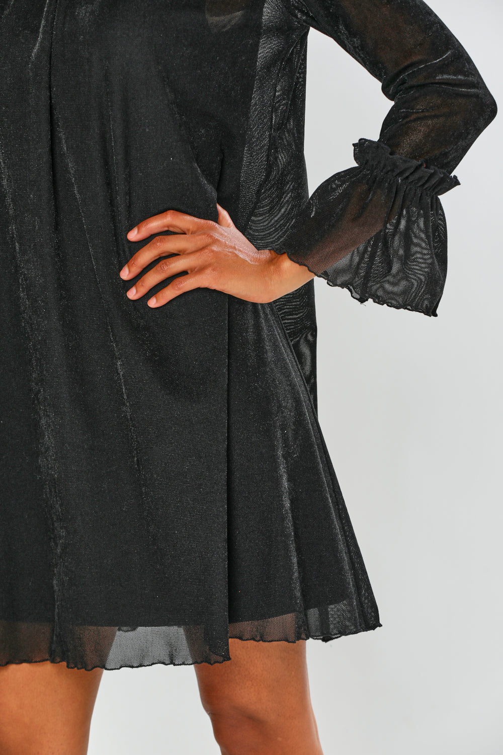 Black dress with sheer long sleeves on a white background
