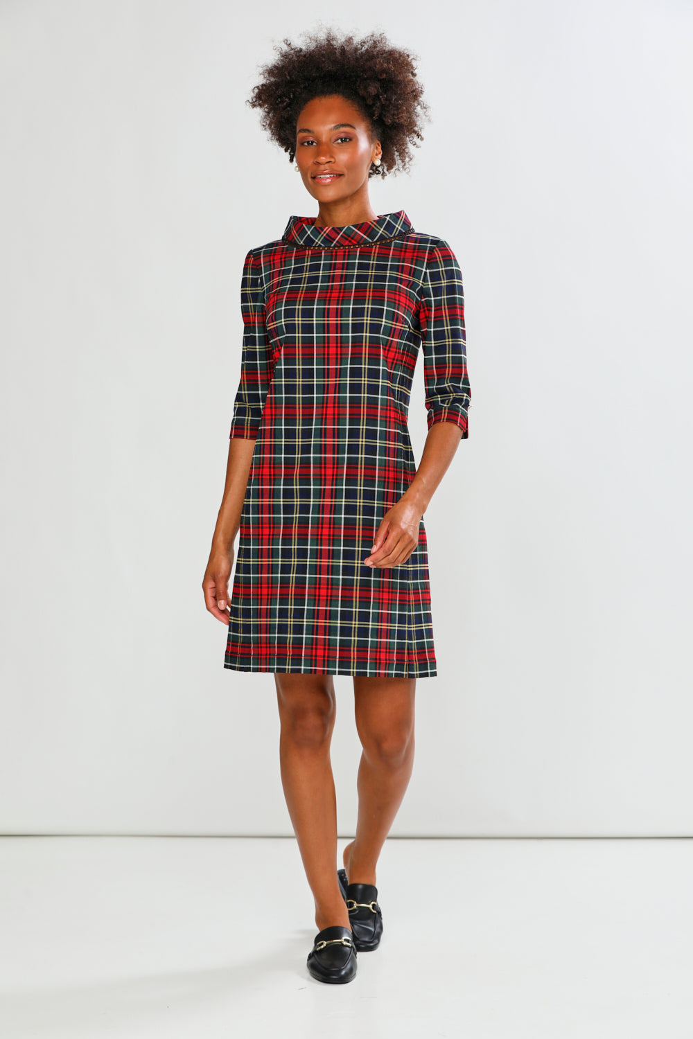 Woman wearing a plaid dress against a white background