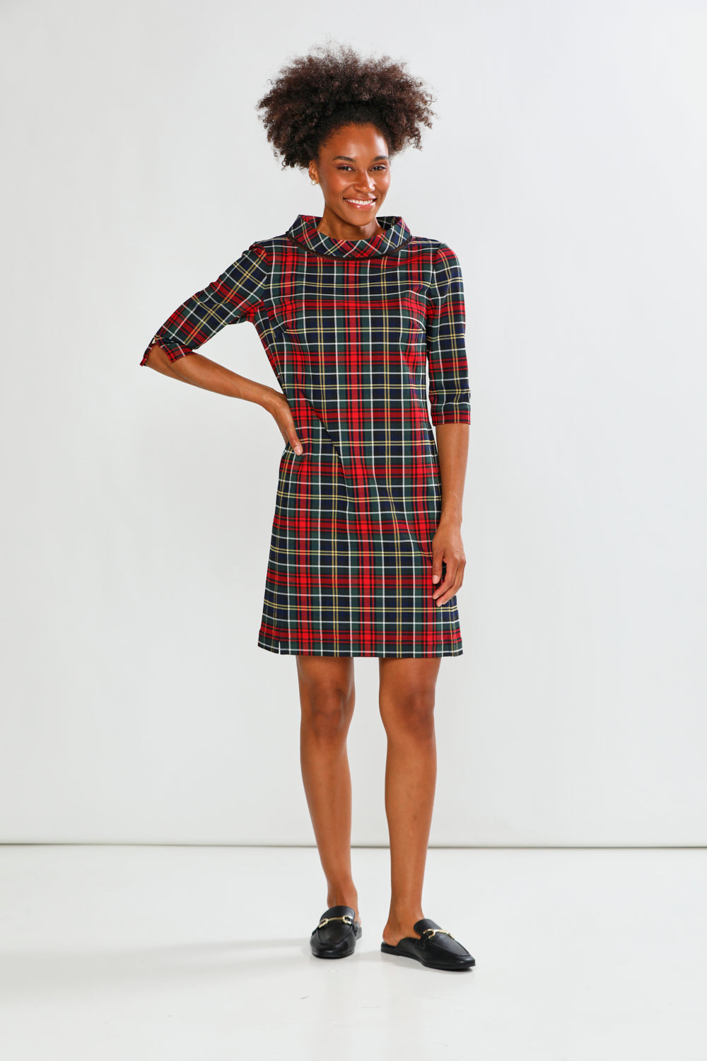 Woman wearing a plaid dress against a white background