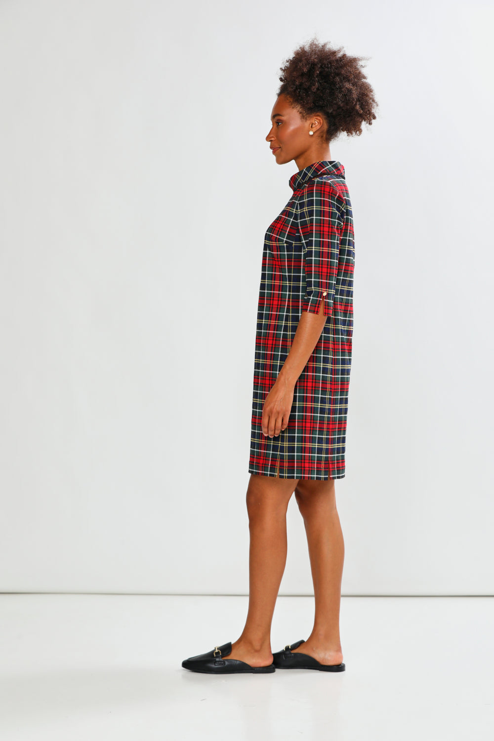 Person wearing a plaid dress against a white background