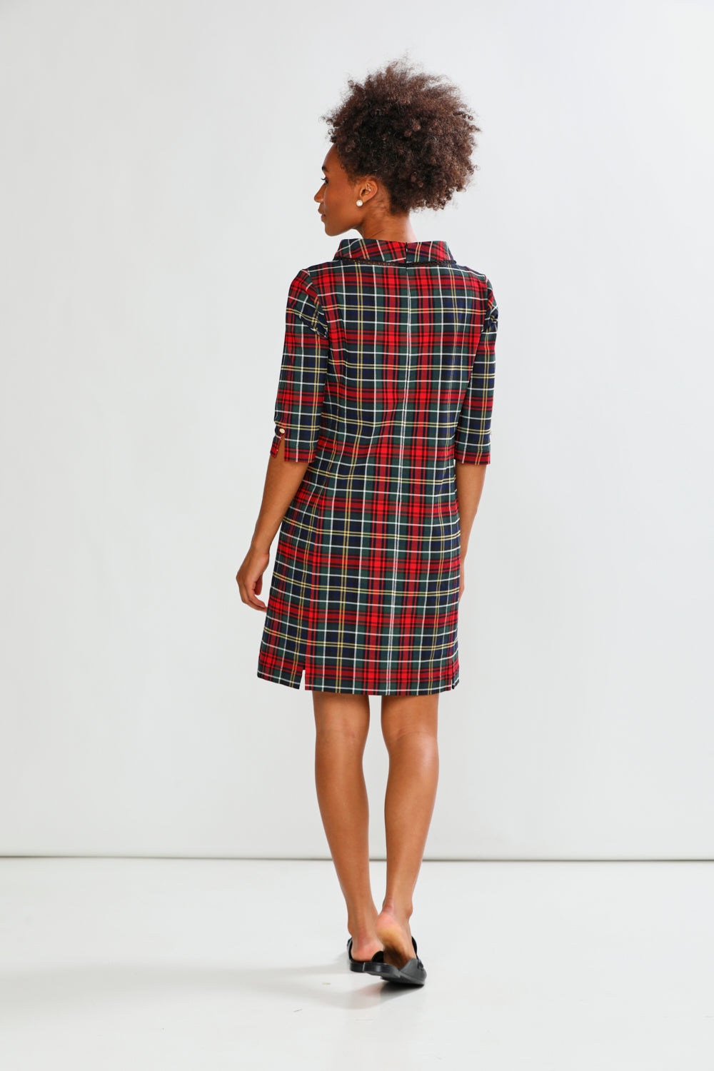 Person wearing a plaid dress on a white background