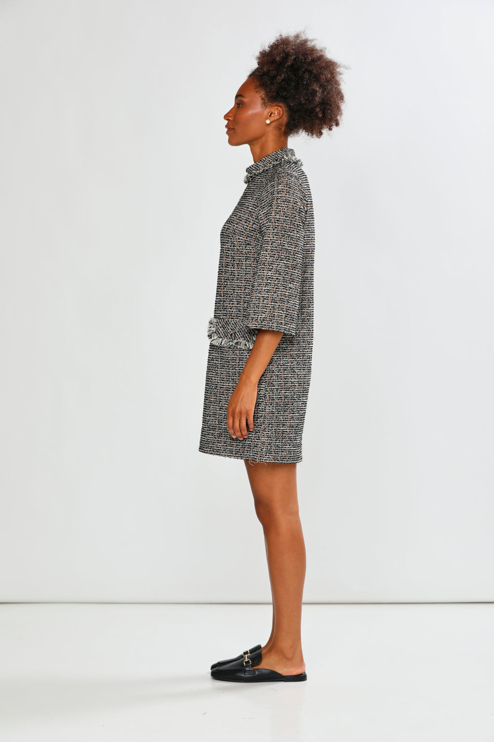 Woman wearing a patterned dress standing against a white background