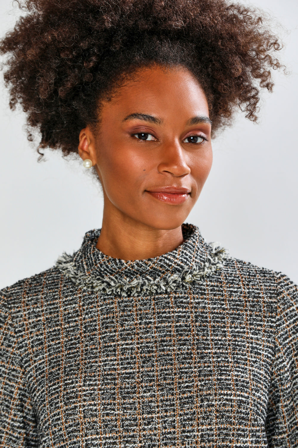 Woman wearing a textured dress against a plain background