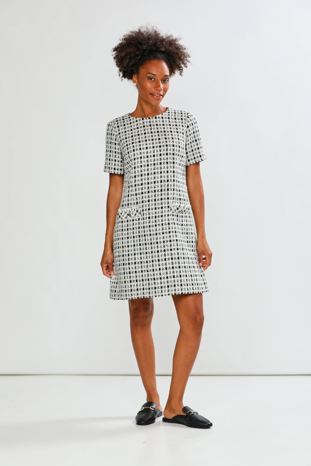 Woman wearing a black and white checkered dress against a white background