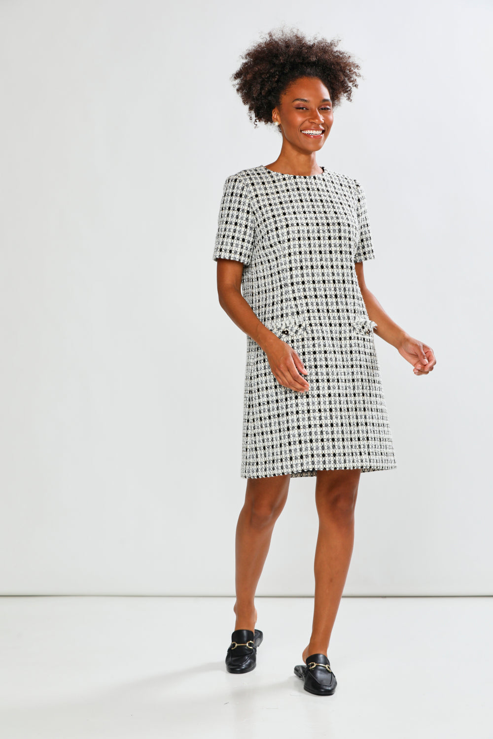 Woman wearing a checkered dress against a white background
