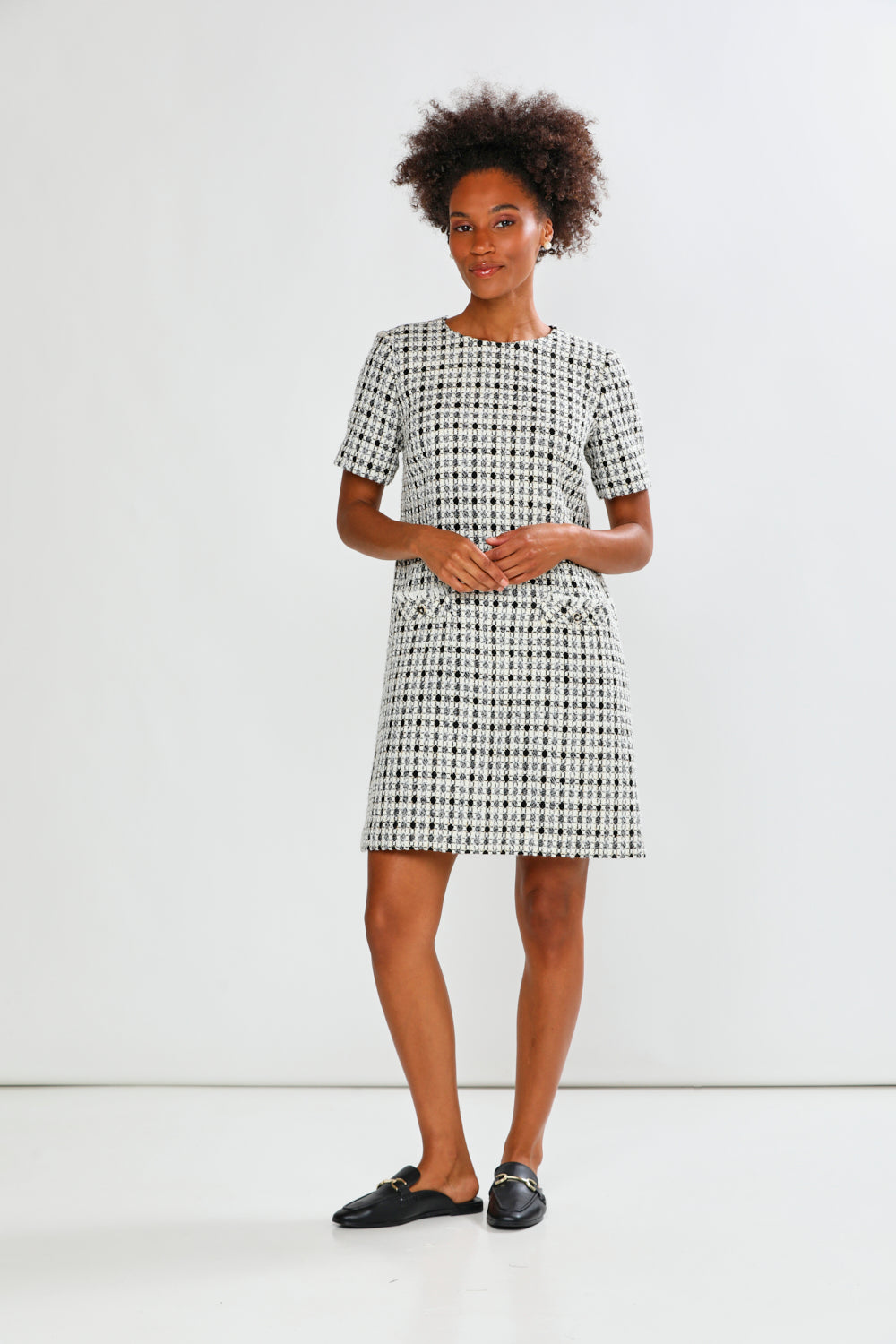 Woman wearing a black and white checkered dress against a white background