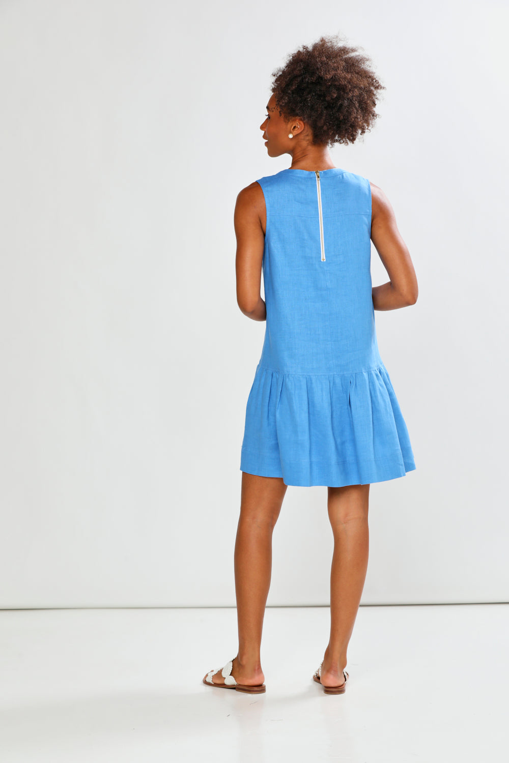 Woman wearing a light blue dress against a white background