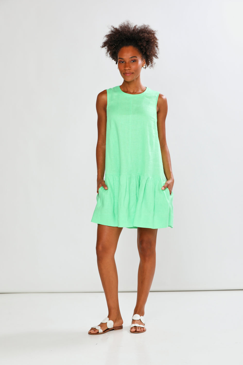 Woman wearing a light green dress against a white background