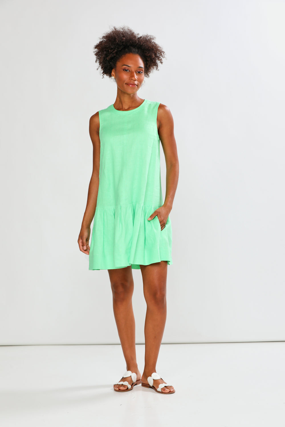 Woman wearing a light green dress against a white background