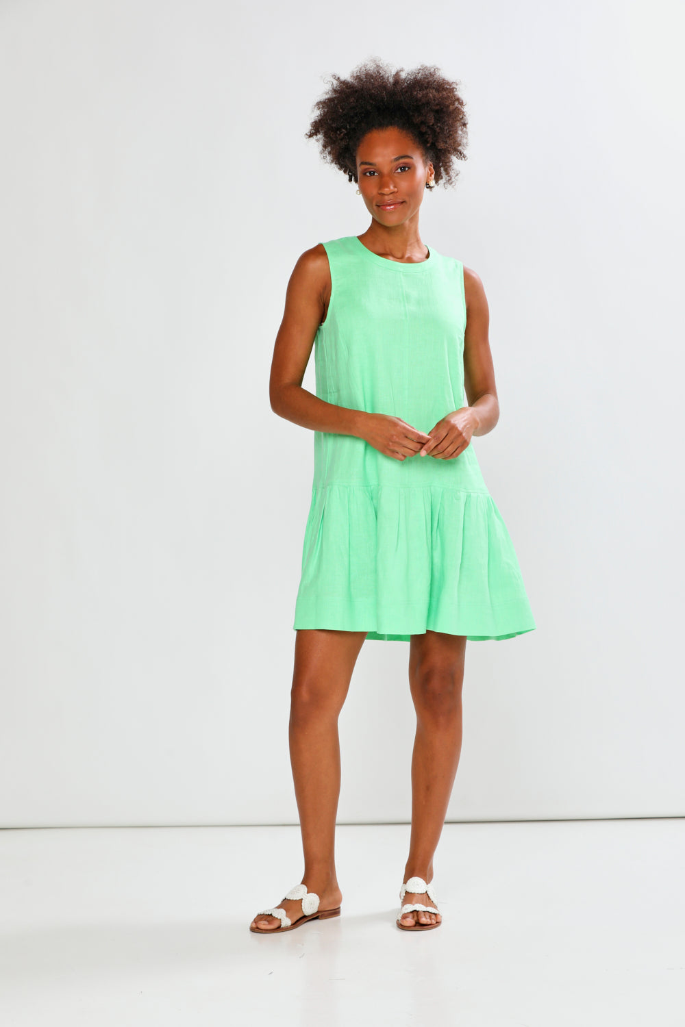 Woman wearing a light green dress against a white background