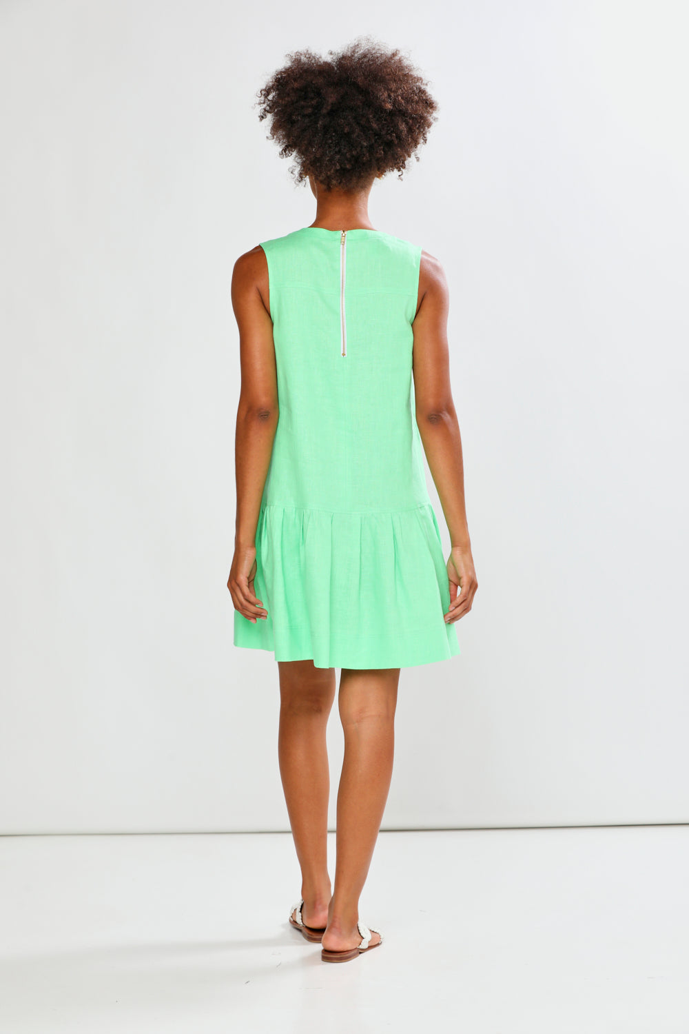 Person wearing a light green dress on a white background