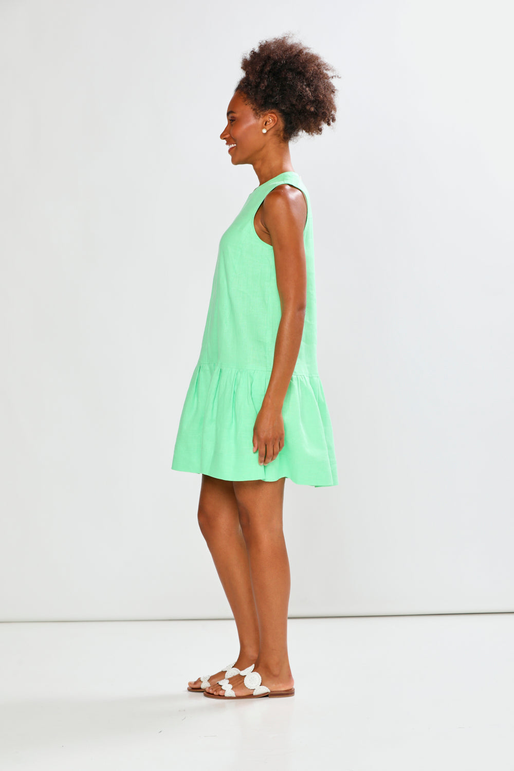 Woman wearing a light green dress against a white background