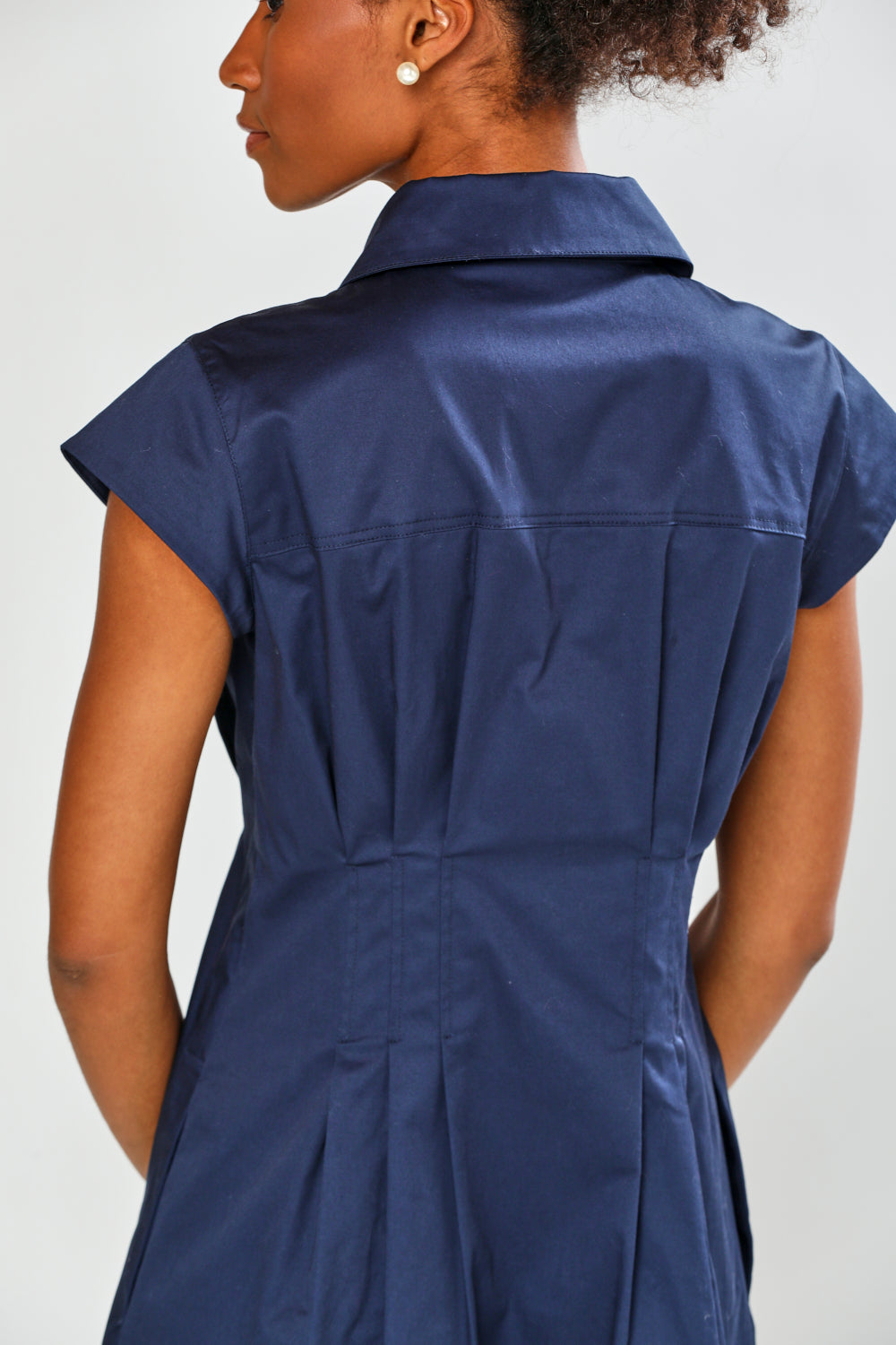 Navy blue dress worn by a person on a white background