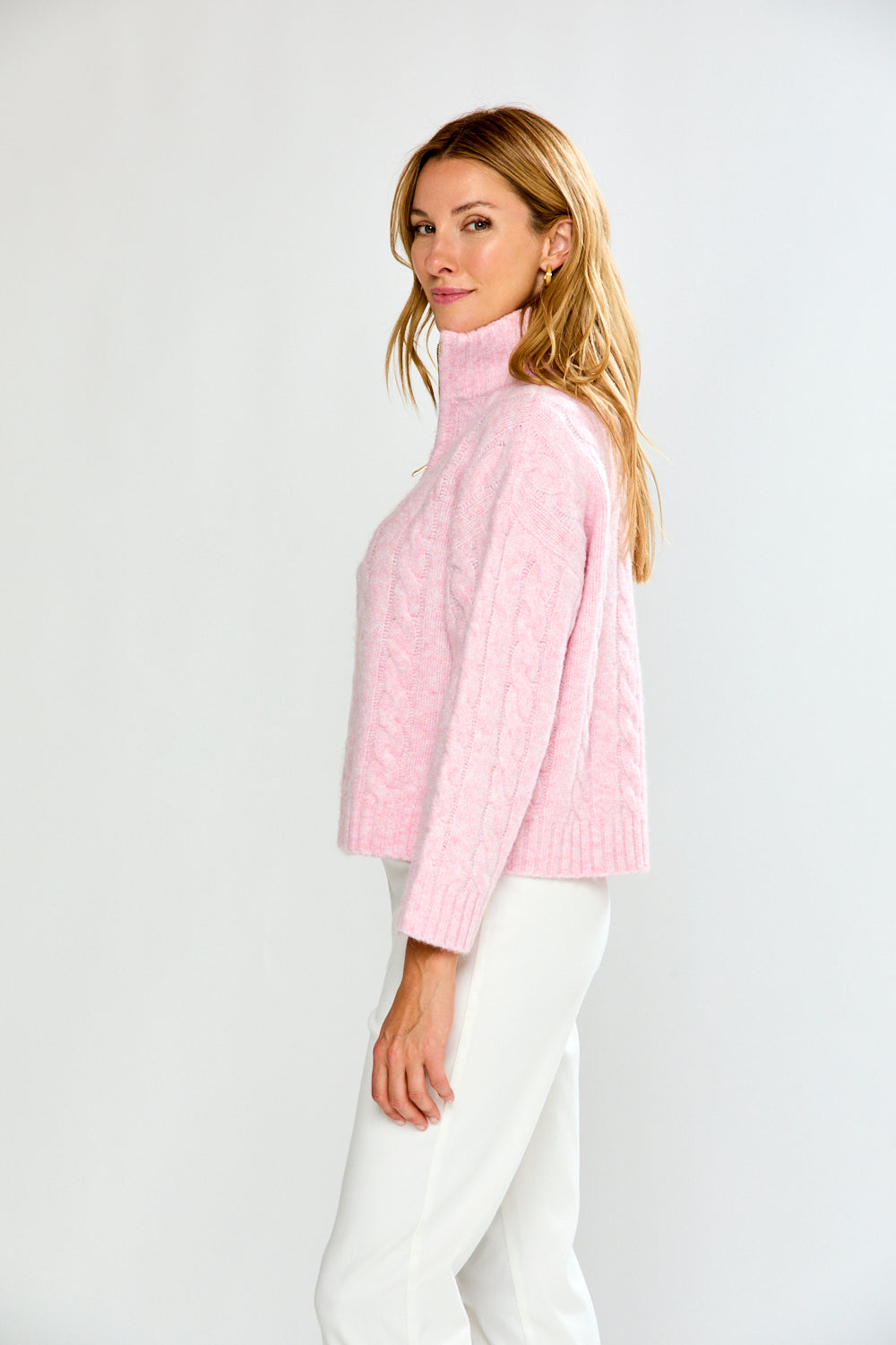Woman wearing a pink pullover with a zipper on a white background
