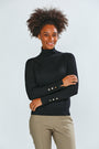 The Turtleneck With Button Cuffs - Black worn with khaki pants on a smiling model showcasing a sophisticated women's sweater