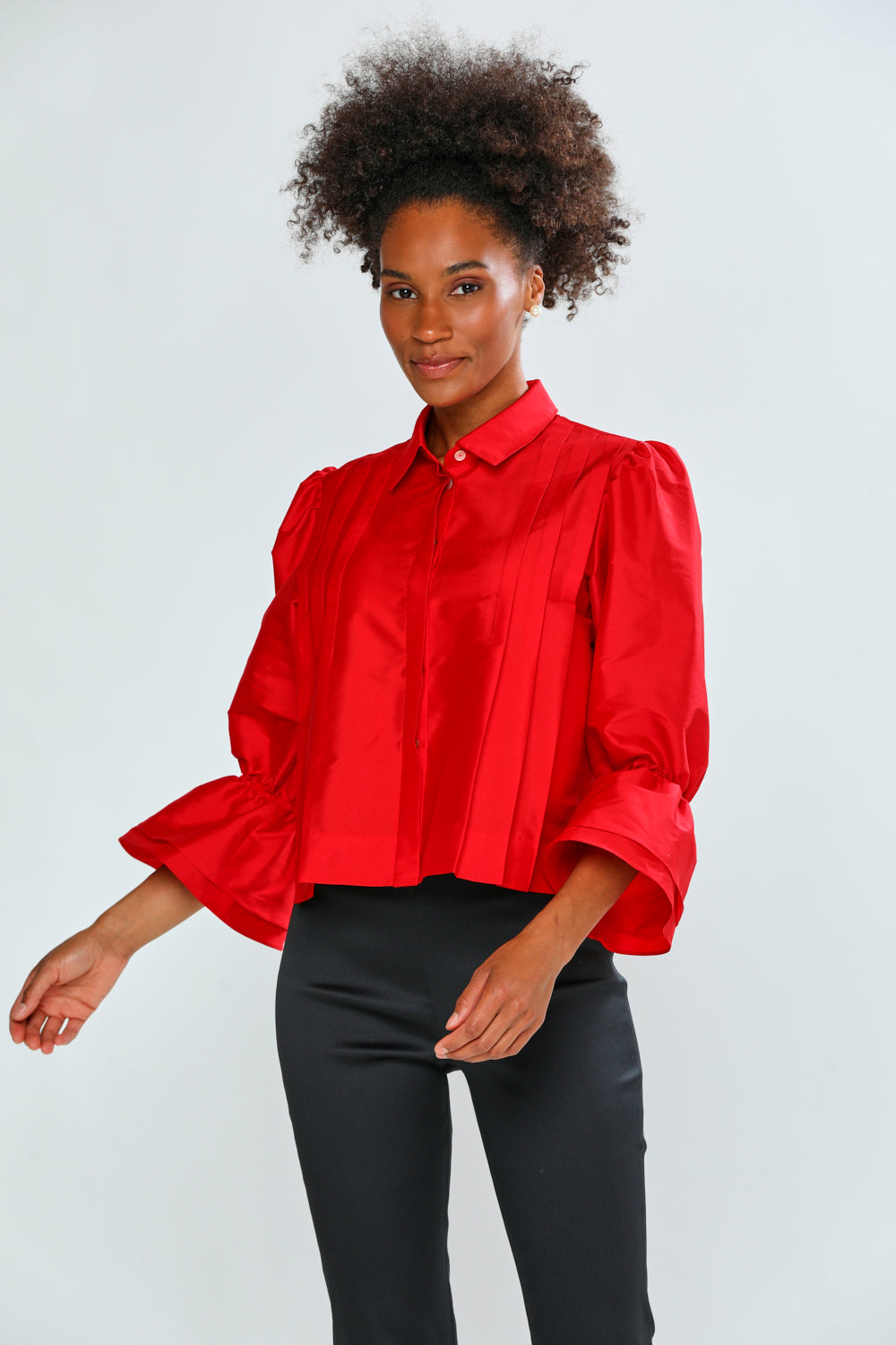 Woman wearing a red blouse with puffed sleeves on a white background