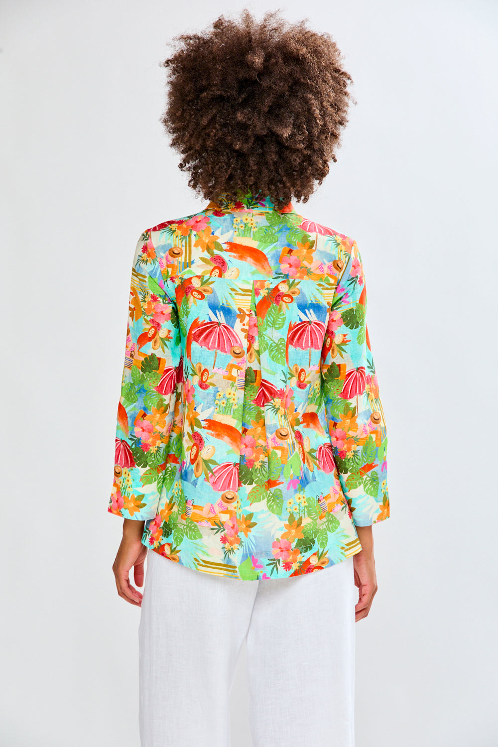 woman in tropical shirt and white pants