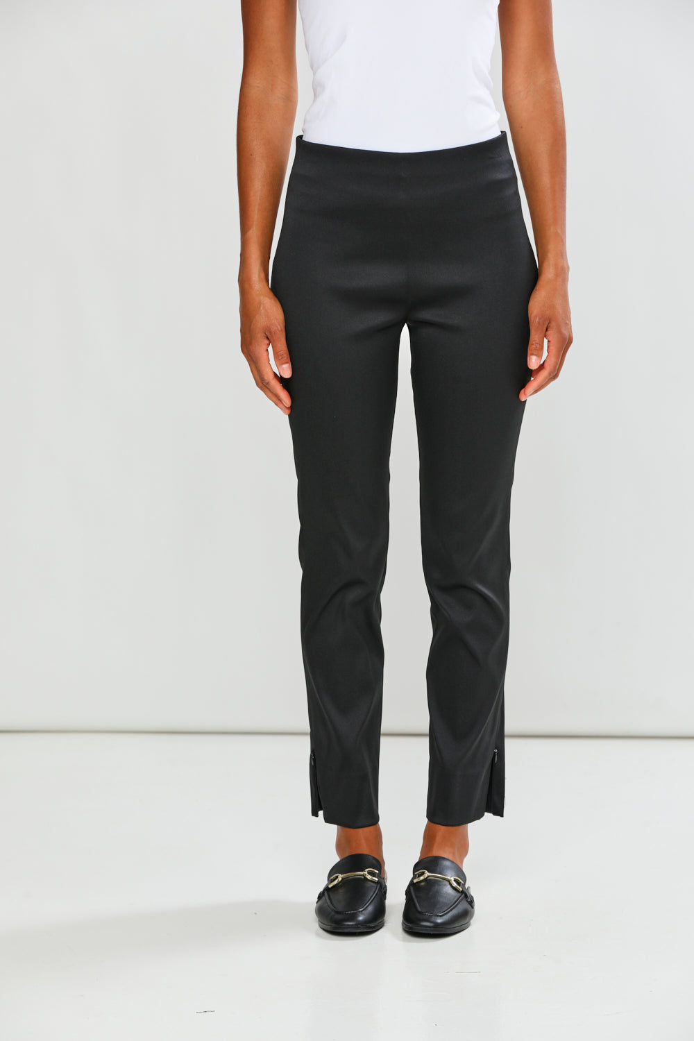 Person wearing black pants on a white background